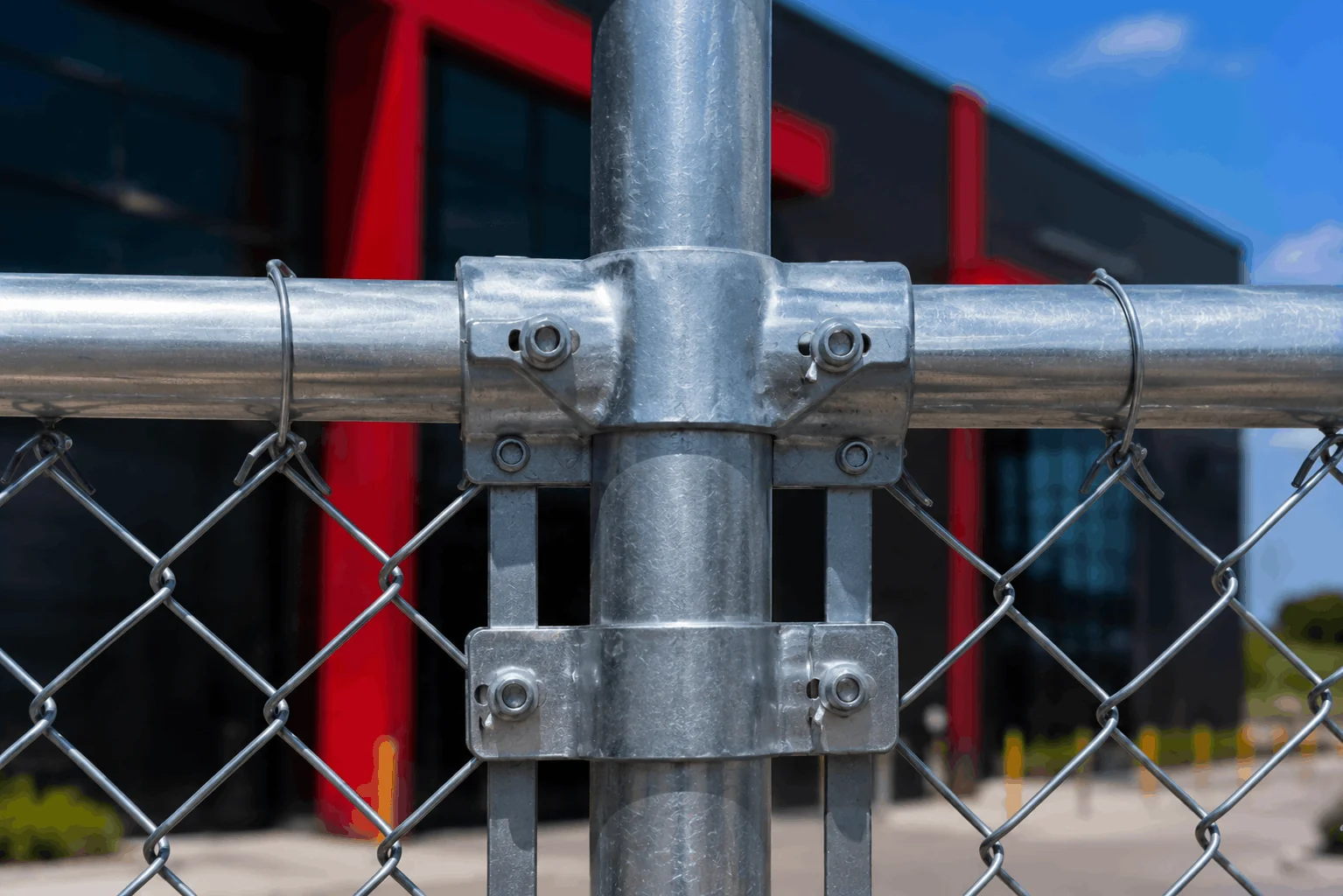 Rail clamps and post clamps securing chainwire fence framework.